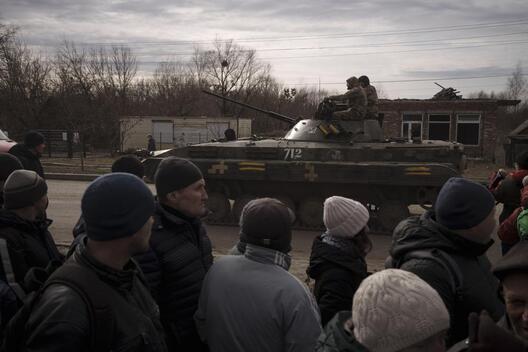 Жыхары Трасцянца, якія стаяць у чарзе па гуманітарную дапамогу, назіраюць за тым, як украінскія вайскоўцы едуць у горад на танках. AP Photo/Felipe Dana Жыхары Трасцянца, якія стаяць у чарзе па гуманітарную дапамогу, назіраюць за тым, як украінскія вайскоўцы едуць у горад на танках. AP Photo/Felipe Dana