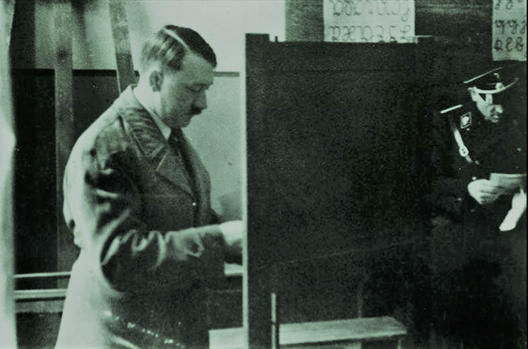 Адольф Гітлер галасуе на апошніх дэмакратычных выбарах у Нямеччыне ў сакавіку 1933 года. Наступныя адбудуцца толькі пасьля вайны. Адольф Гітлер галасуе на апошніх дэмакратычных выбарах у Нямеччыне ў сакавіку 1933 года. Наступныя адбудуцца толькі пасьля вайны.