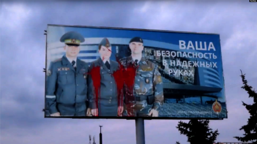 Адзін са шчытоў сацыяльнай рэкламы, які нібыта пашкодзілі анархісты. Артура Кандратовіча вінавацяць у падпале рэкламнага шчыта з гербам Міністэрства юстыцыі і надпісам «Сіла закону ў яго выкананні» Адзін са шчытоў сацыяльнай рэкламы, які нібыта пашкодзілі анархісты. Артура Кандратовіча вінавацяць у падпале рэкламнага шчыта з гербам Міністэрства юстыцыі і надпісам «Сіла закону ў яго выкананні»