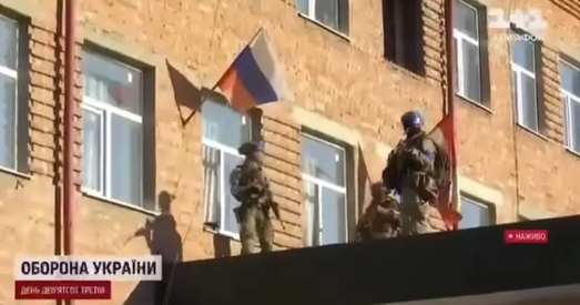 903-ці дзень вайны. Украінскія вайскоўцы здымаюць расійскі сцяг з дзяржаўнага будынка ў Суджы.